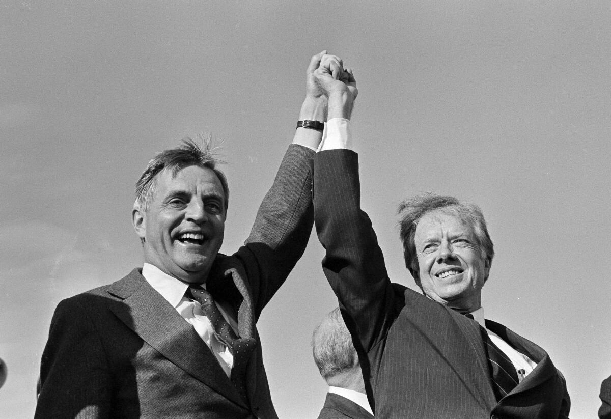 President Carter and Walter Mondale raising their clasped hands.