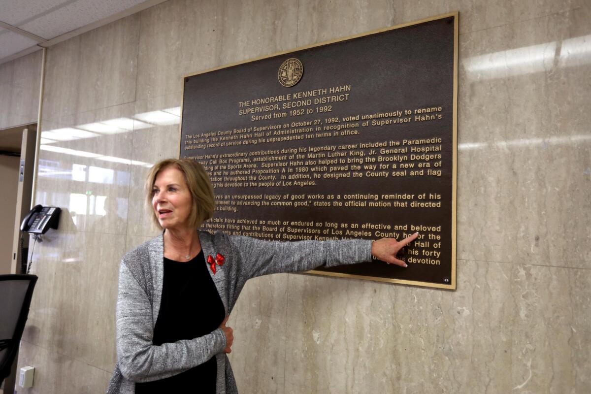 Janice Hahn points to a plaque on a wall