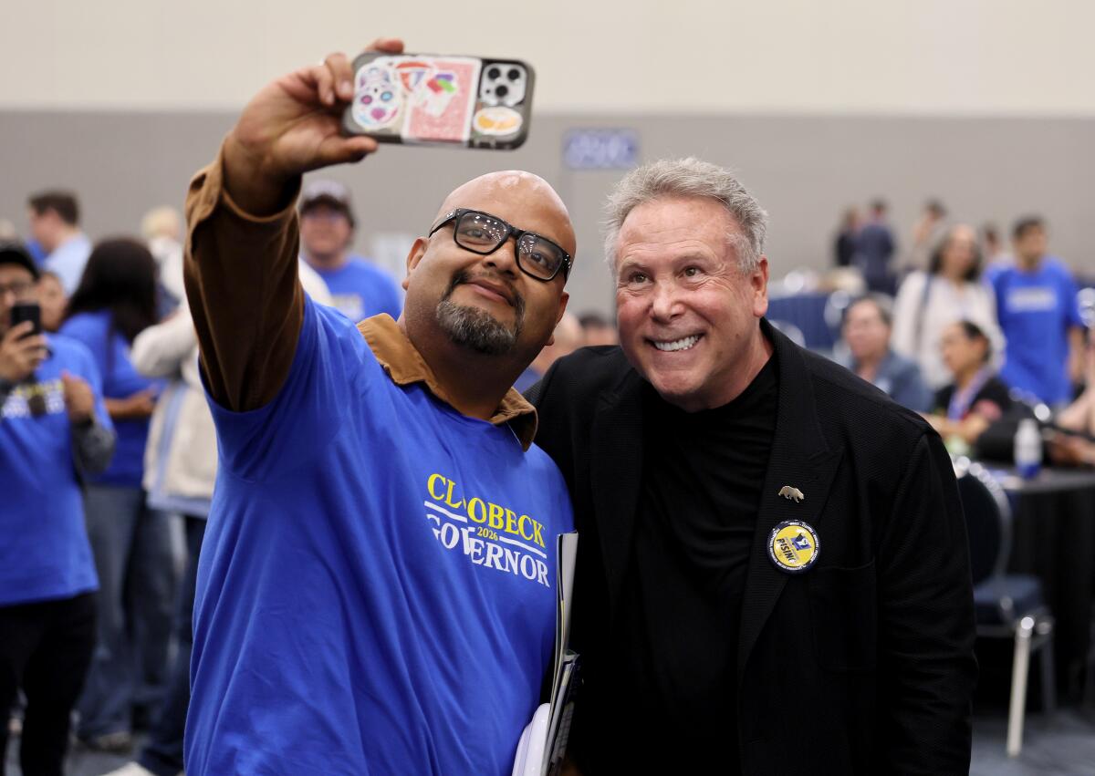 Philanthropist and businessman Stephen Cloobeck, right, takes a photo with a supporter